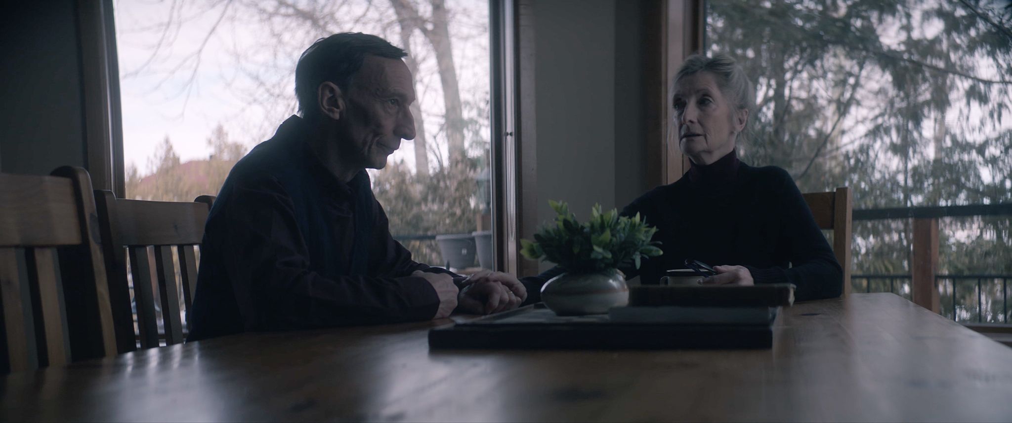 Grandparents [Julian Richings & Sheila McCarthy] sit at the table discussing their occult plans in Anything for Jackson. Photo credit: Dyck, Justin. dir. Anything For Jackson. 2020.
