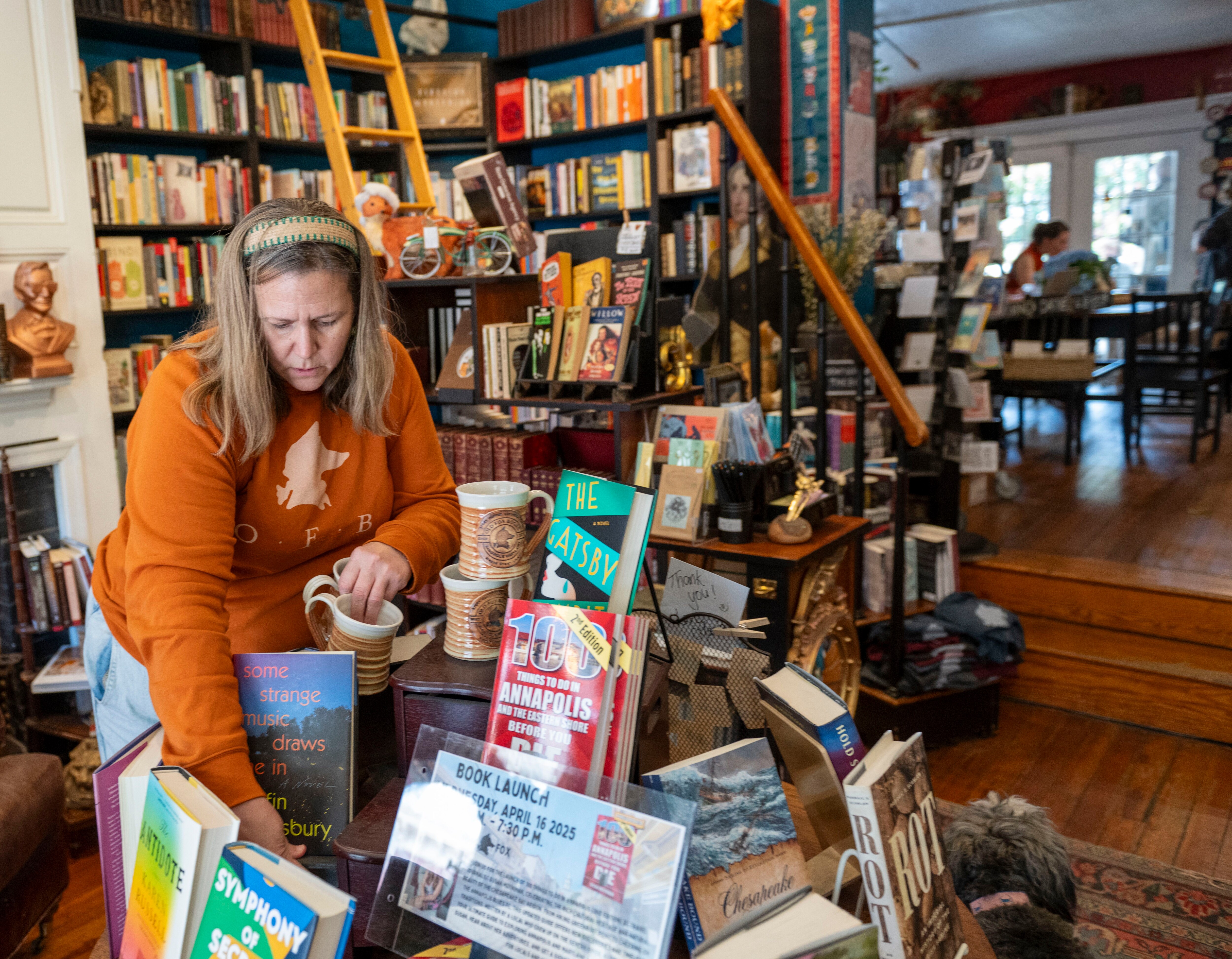 Jinny Amundson stocks a circular display of books banned by the U.S. Naval Academy.
